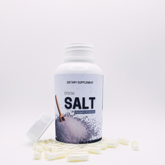 Bottle of Epsom salt dietary supplement with loose salt crystals on a white background
